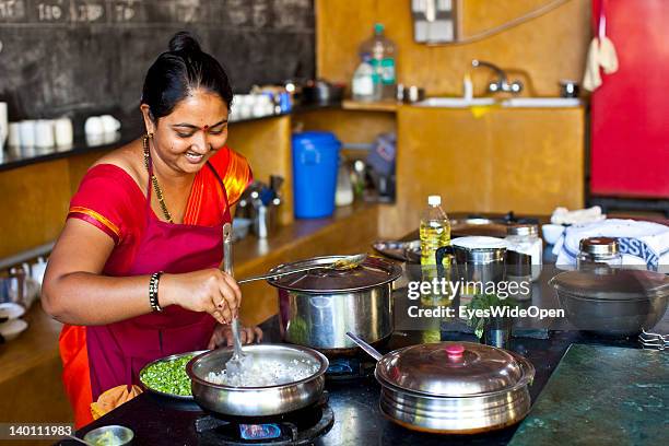 Indian woman Gita, the chef, prepares yellow lentil curry food in the kitchen of Yoga Magic Eco Retreat in Anjuna on February 1, 2012 in Goa, India