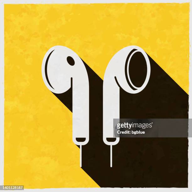 kopfhörer. symbol mit langem schatten auf strukturiertem gelbem hintergrund - in ear headphones stock-grafiken, -clipart, -cartoons und -symbole