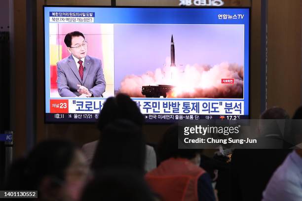 People watch a television broadcast showing a file image of a North Korean missile launch at the Seoul Railway Station on June 05, 2022 in Seoul,...