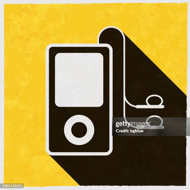mp3 player with earphones. icon with long shadow on textured yellow background - old ipod stock illustrations