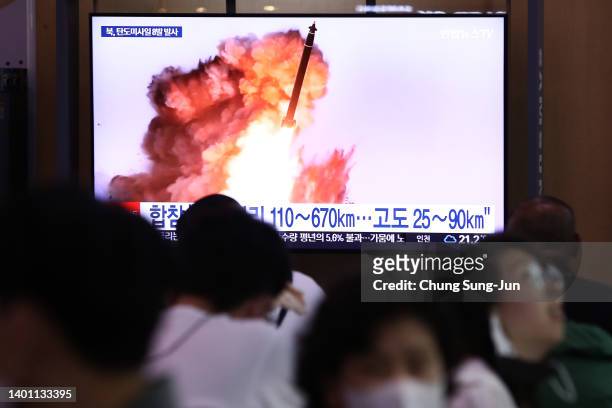 People watch a television broadcast showing a file image of a North Korean missile launch at the Seoul Railway Station on June 05, 2022 in Seoul,...