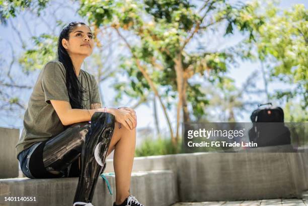 disabled woman looking away contemplating at the park - latin beauty stockfoto's en -beelden