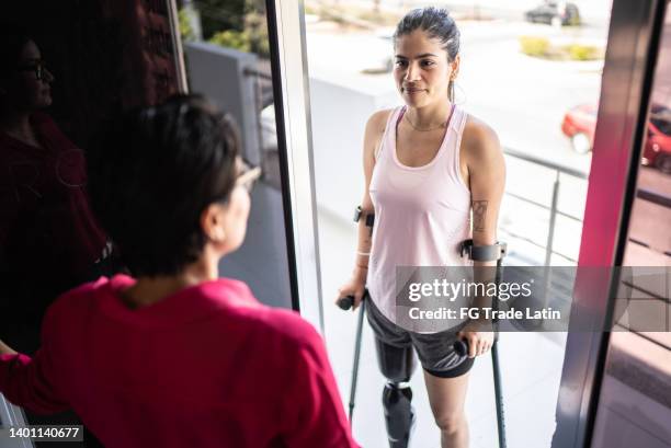 receptionist greeting disabled mid adult woman - sportswear retail stock pictures, royalty-free photos & images