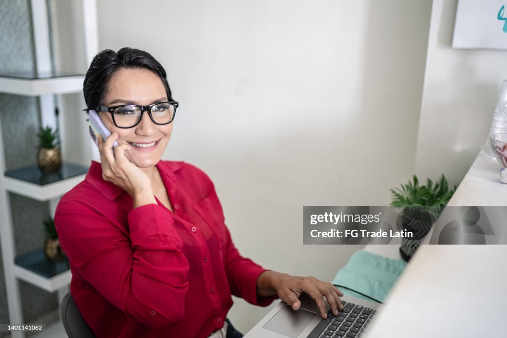 Portrait of receptionist using mobile phone at reception desk