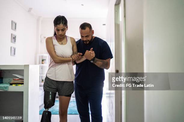 disabled mid adult woman being helped by physiotherapist - amputee rehab stock pictures, royalty-free photos & images
