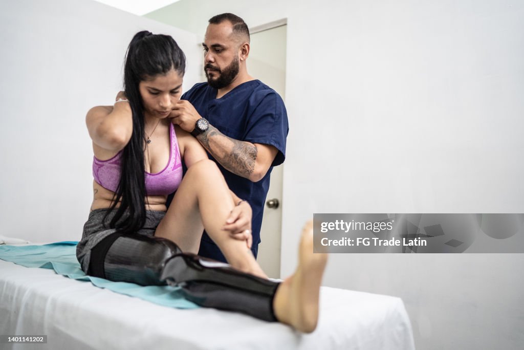 Physiotherapist giving therapy to disabled mid adult woman
