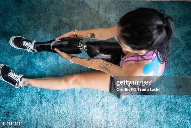 disabled mid adult woman getting dressed - carbon fibre stockfoto's en -beelden