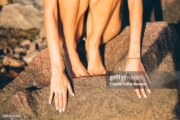 woman wearing swimsuit sitting on a rock - couleur chair photos et images de collection