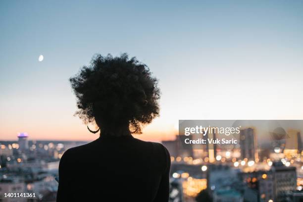 afrikanische frau mit blick auf die stadt - black woman no face stock-fotos und bilder