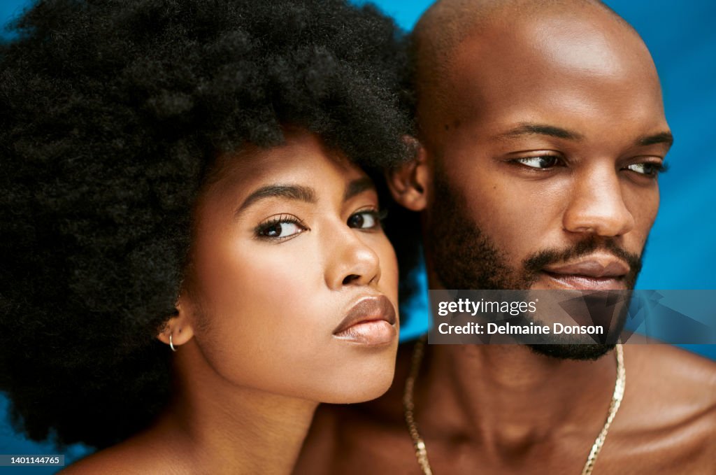 Closeup of two models in a studio promoting clear skin. Portrait of an African millennial couple with their faces close to each other while standing against a blue background