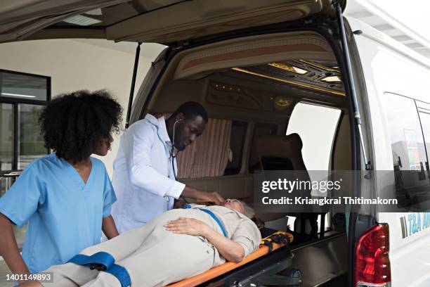 doctor is checking senior female patient while transferring to emergency room. - stretcher photos et images de collection