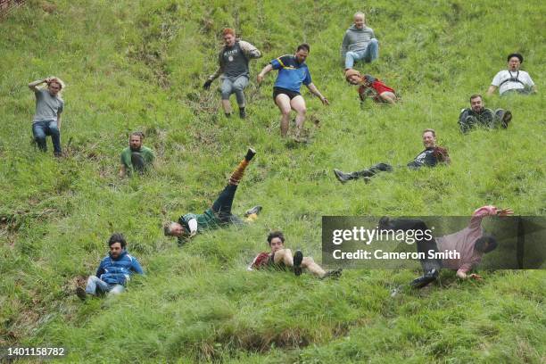 Contestants in the men's downhill race chase the cheese down the hill on June 05, 2022 in Gloucester, England. The Cooper's Hill Cheese-Rolling and...