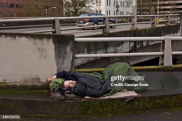 Homeless man sleeps on a downtown roadway overpass on February 11, 2012 in Portland, Oregon. Portland has embraced its national reputation as a city...