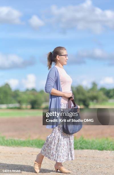 a woman walking in the rural on a sunny day - woman omg stock pictures, royalty-free photos & images