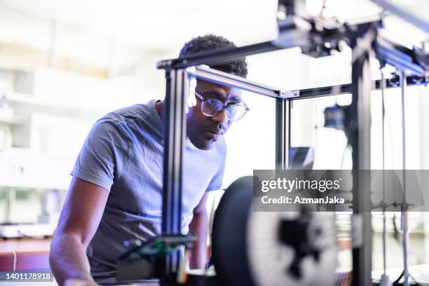 male engineer looking at 3d printer - mockup identity stock pictures, royalty-free photos & images