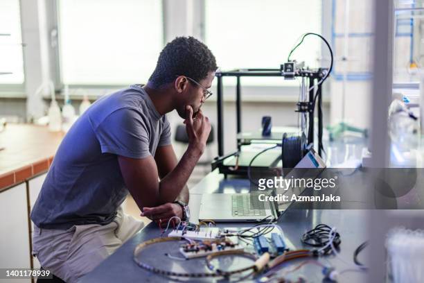 junger designer während seiner arbeit im labor - 3d printer stock-fotos und bilder