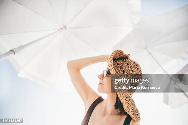 woman relaxing on beach. - solskärm bildbanksfoton och bilder