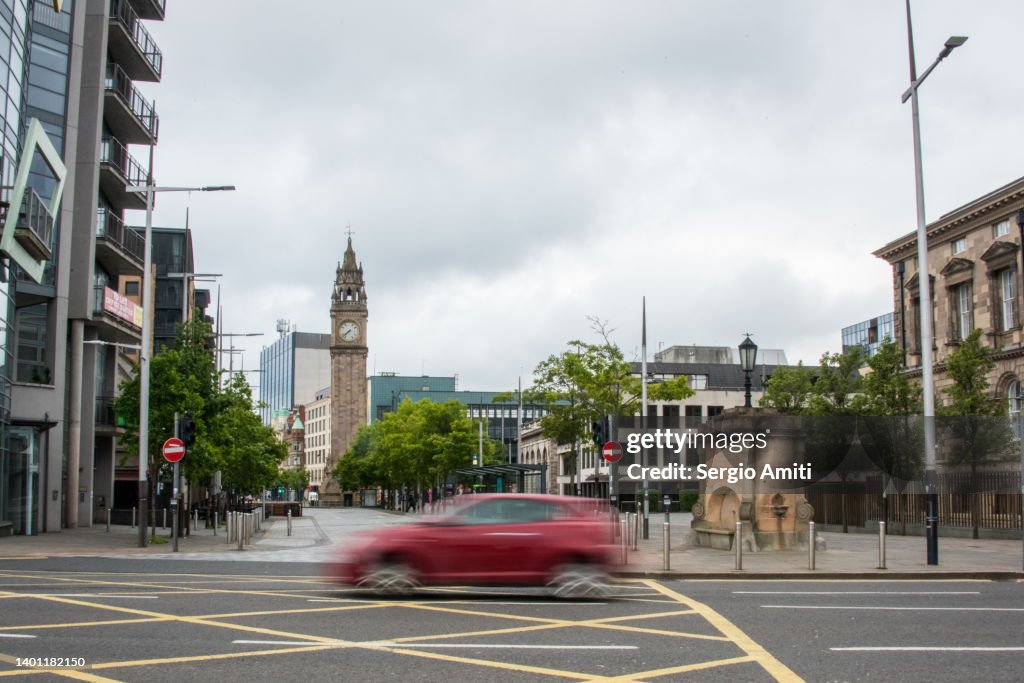 Red car driving by Queen’s Square, Belfast