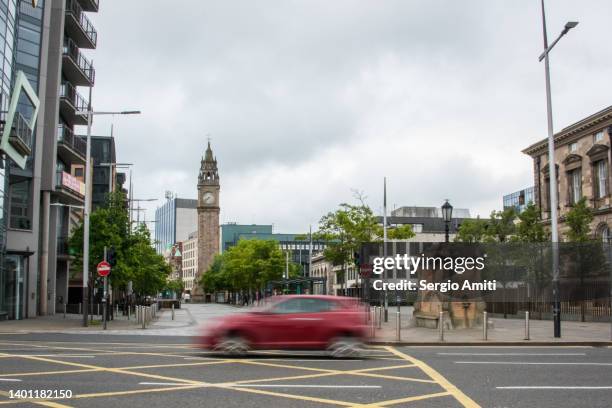 red car driving by queen’s square, belfast - urban road stock pictures, royalty-free photos & images