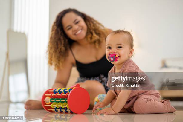 mother watching baby playing with children's toy. - baby gender reveal stock pictures, royalty-free photos & images