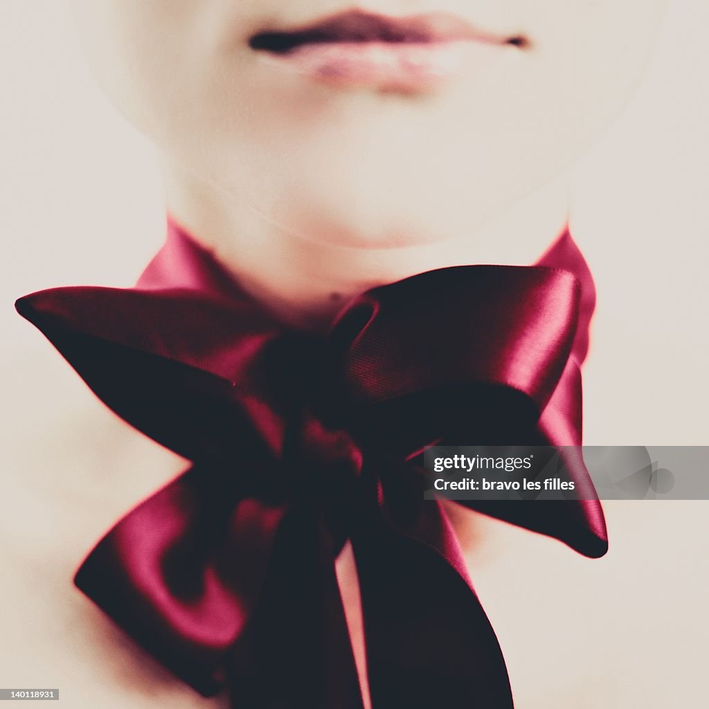 Woman with huge red ribbon on her neck