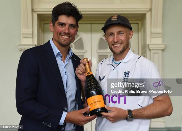 Sir Alastair Cook presents Joe Root of England with a signed bottle of Veuve Clicquot champagne after Root joined Cook in scoring 10,000 Test runs...