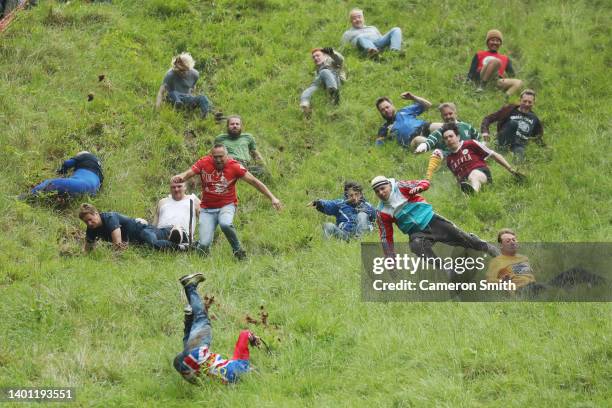 Contestants in the men's downhill race chase the cheese down the hill on June 05, 2022 in Gloucester, England. The Cooper's Hill Cheese-Rolling and...