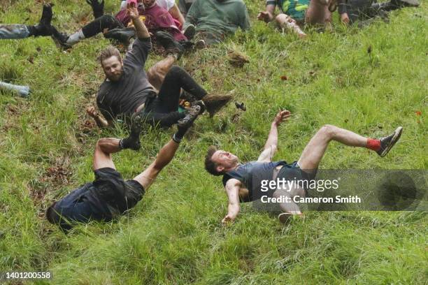 Contestants in the men's downhill race chase the cheese down the hill during Gloucestershire's famous Cheese-Rolling contest on June 05, 2022 in...