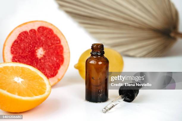 anti-aging skin care cosmetics with vitamin c serum or essential skin oil, dropper bottle and citrus lemon orange grapefruit, aromatherapy essential oil - orange creme stock pictures, royalty-free photos & images