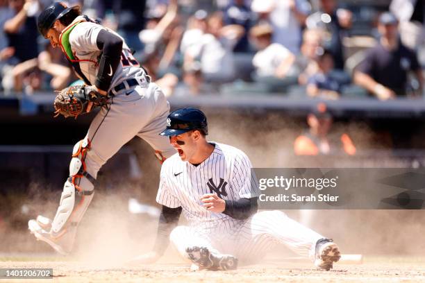 Anthony Rizzo of the New York Yankees reacts after sliding safely into home to score on an error and tie the game during the eighth inning against...