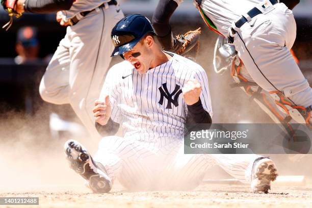 Anthony Rizzo of the New York Yankees reacts after sliding safely into home to score on an error and tie the game during the eighth inning against...