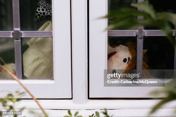 trapped: homemade paper mache doll visible in residential window - looking through a doll house photos et images de collection