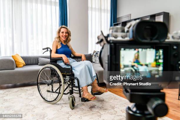 video blogger. inspired young woman sitting in wheelchair talk speak in front of camera - celebrity connected stock pictures, royalty-free photos & images