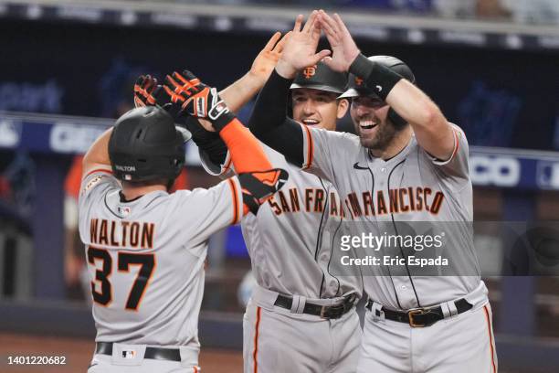 Donovan Walton of the San Francisco Giants high fives Curt Casali at home plate after hitting a grand slam in the fourth inning against the Miami...
