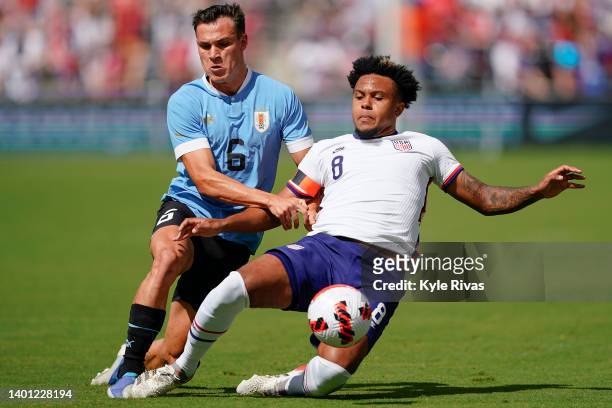 Manuel Ugarte of Uruguay has the ball knocked away by Weston McKennie of USA during the first half of the friendly matchat Children's Mercy Park on...