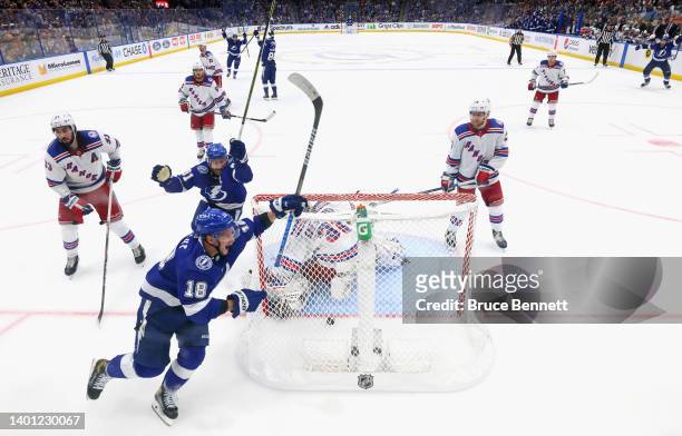 Ondrej Palat of the Tampa Bay Lightning celebrates scoring the game-winning goal past Igor Shesterkin of the New York Rangers as he is joined by...