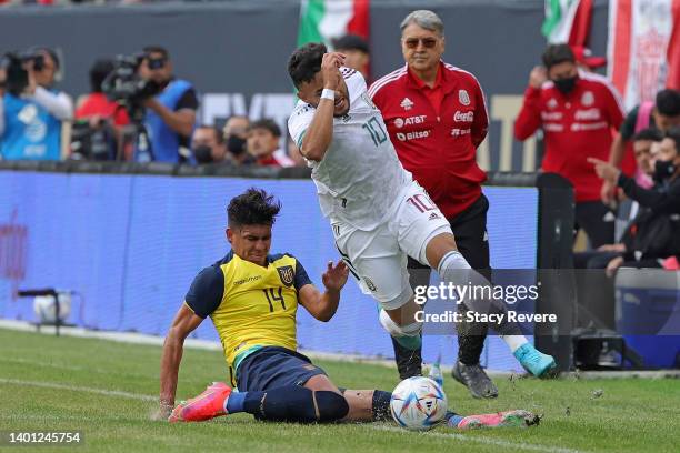 Alexis Vega Rojas of Mexico is tripped up by Xavier Ricardo Arreaga Bermello of Ecuador in the first half during an International friendly match at...