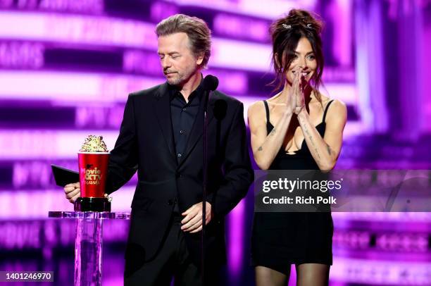 David Spade and Sarah Shahi speak onstage during the 2022 MTV Movie & TV Awards at Barker Hangar on June 05, 2022 in Santa Monica, California.