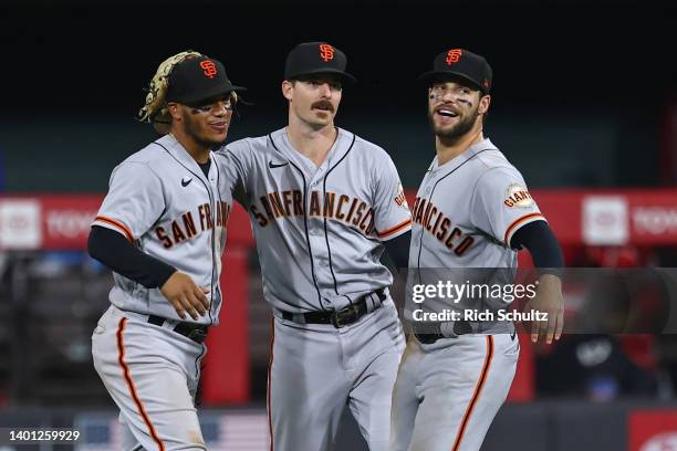 Outfielders Thairo Estrada, Mike Yastrzemski and Luis Gonzalez of the San Francisco Giants celebrate after defeating the Philadelphia Phillies 7-4 in...