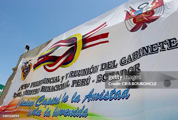 Workers pull up a gigantic banner on February 28 in a main street of the city of Chiclayo, 760 km north of Lima, announcing the Presidential...