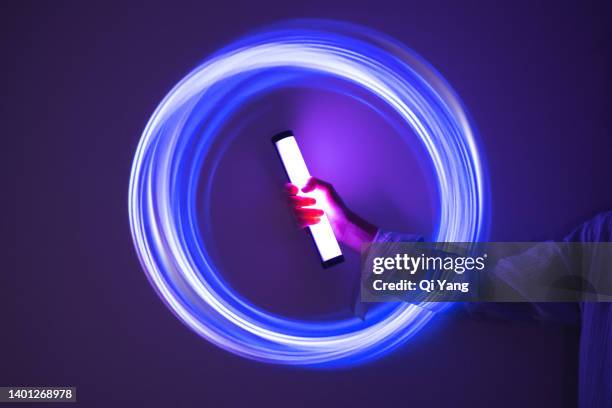 holding a glow stick on holographic background - novelty automation stock pictures, royalty-free photos & images
