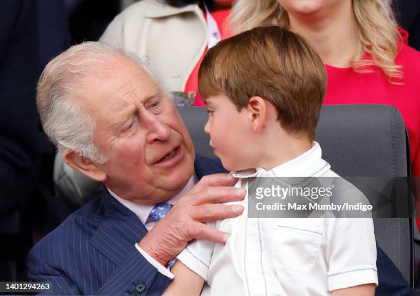 Prince Louis of Cambridge sits on his grandfather Prince Charles, Prince of Wales's lap as they attend the Platinum Pageant on The Mall on June 5,...