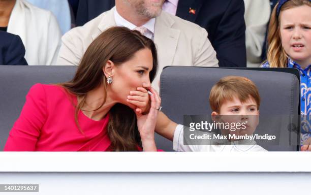 Prince Louis of Cambridge covers his mother Catherine, Duchess of Cambridge's mouth with his hand as they attend the Platinum Pageant on The Mall on...