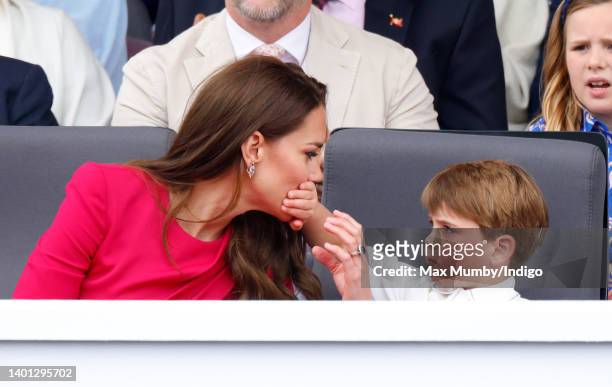 Prince Louis of Cambridge covers his mother Catherine, Duchess of Cambridge's mouth with his hand as they attend the Platinum Pageant on The Mall on...