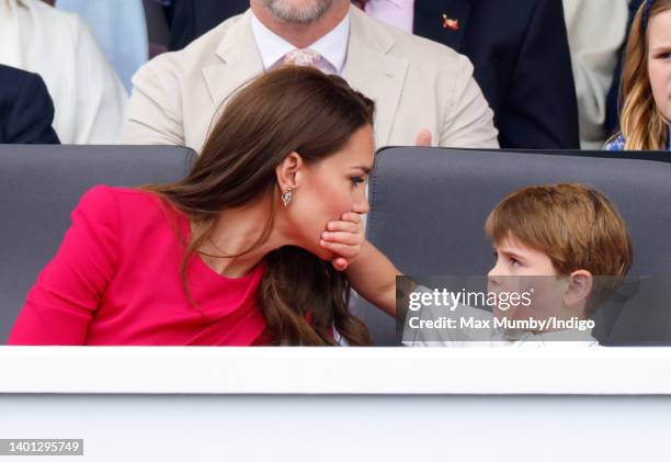 Prince Louis of Cambridge covers his mother Catherine, Duchess of Cambridge's mouth with his hand as they attend the Platinum Pageant on The Mall on...