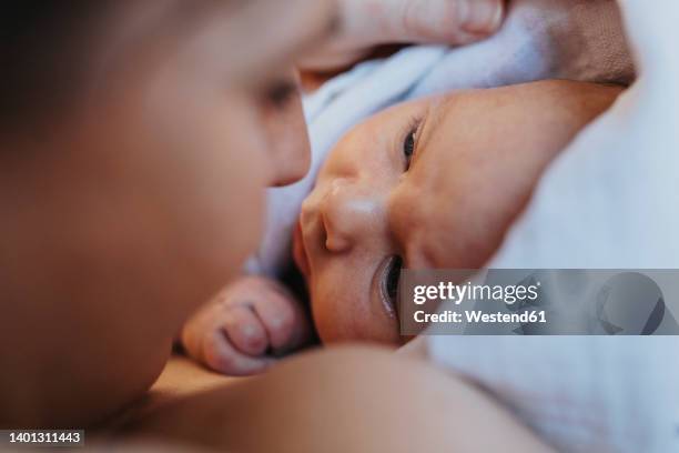 mother looking at baby wrapped in towel - home birth - fotografias e filmes do acervo
