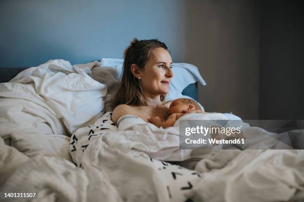 baby sleeping on mother at home - home birth stock-fotos und bilder