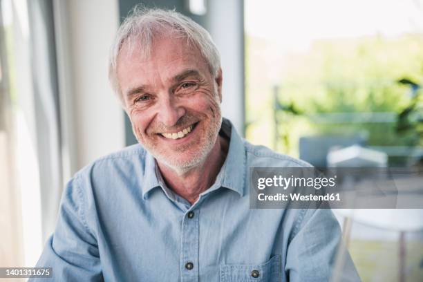 happy senior man with gray hair sitting at home - westend61 fotografías e imágenes de stock