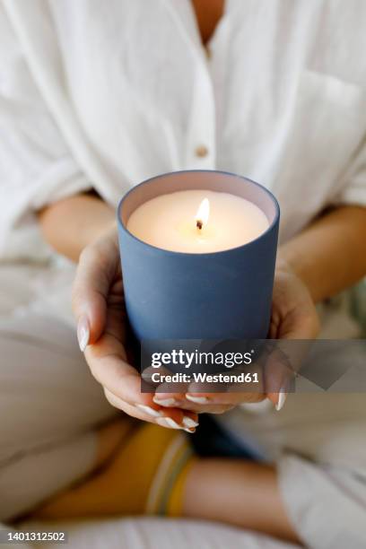 hands of woman holding scented candle at home - scented candle stock pictures, royalty-free photos & images