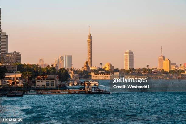egypt, cairo, pier in gezira district at dusk with cairo tower and downtown skyline in background - egypt city stock pictures, royalty-free photos & images